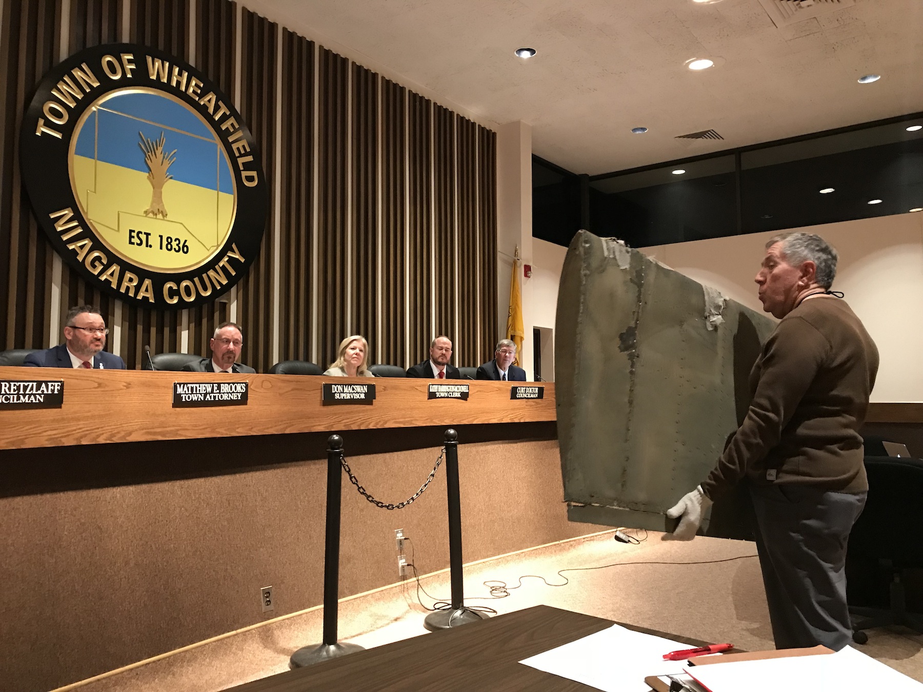 Tom Kontak presents the rear elevator of the helicopter from in front of the town's Highway Department to the Town Board. (Photo by David Yarger)